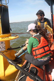 Buoy techs reinstall the water-quality sensor into a buoy