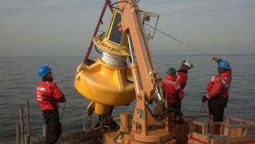 Team lifts new SR buoy from deck of Coast Guard buoy tender