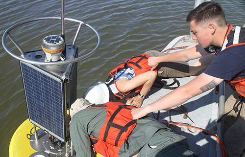 CBIBS team members secure the top structure, including solar panels and meteorological sensors, to the buoy hull